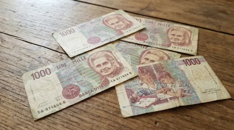 Vecchie banconote italiane da 1000 lire con il ritratto di Maria Montessori su un tavolo in legno